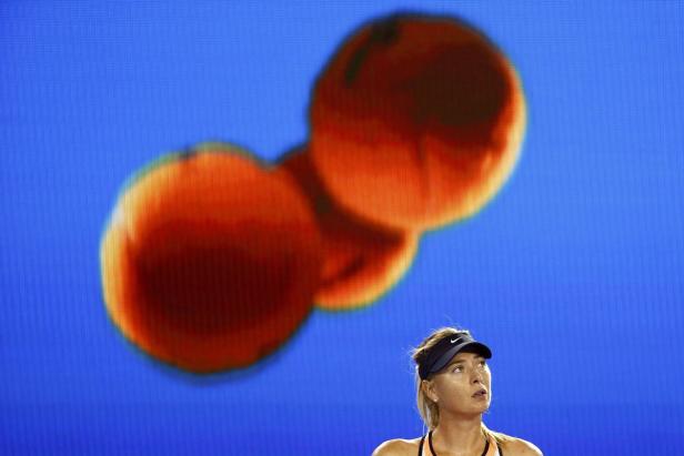 Maria Scharapowa bei einem Tennismatch vor einem blauen Bildschirm mit Orangen.