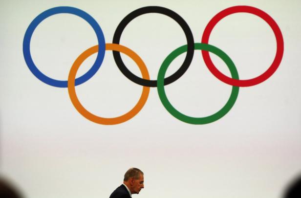 Ein Mann geht unter dem Logo der Olympischen Spiele hindurch.