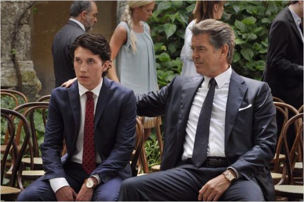 Zwei Männer in Anzügen sitzen nebeneinander auf Stühlen.