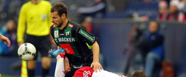 Ein Fußballspieler von FC Wacker foult einen Gegenspieler.