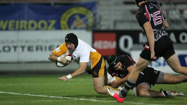 Ein Rugbyspieler versucht, den Ball während eines Spiels zu tragen.