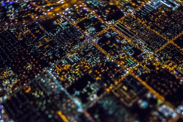 Luftaufnahme einer nachts beleuchteten Stadt mit verschwommenen Lichtern.