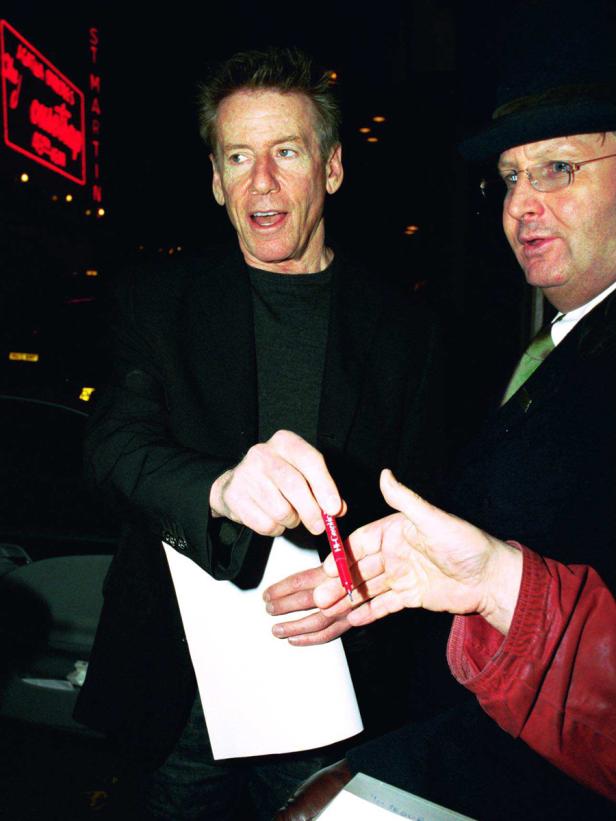 Calvin Klein gibt einem Fan ein Autogramm.