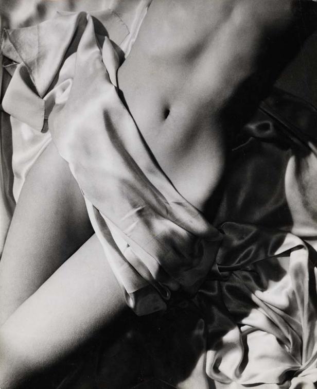 Der Torso einer Person, teilweise mit einem seidigen Stoff bedeckt, im Schwarzweiß-Stil.