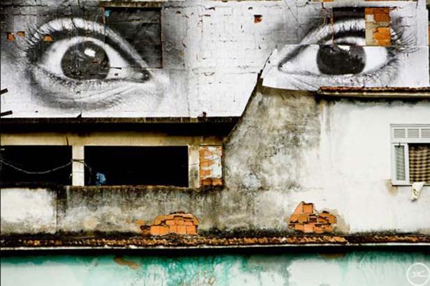 Ein Gebäude mit einem großen Wandbild von Augen.