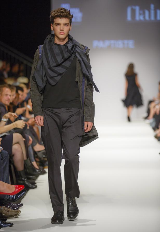 Ein junger Mann präsentiert Mode auf einem Laufsteg.