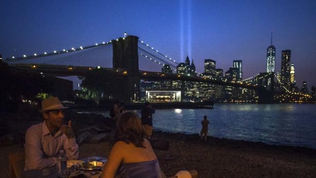 Blick auf die Skyline von New York mit der Brooklyn Bridge und den Lichtern des World Trade Center Memorial.
