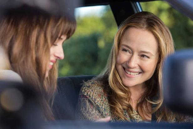 Zwei Frauen sitzen lächelnd in einem Auto.