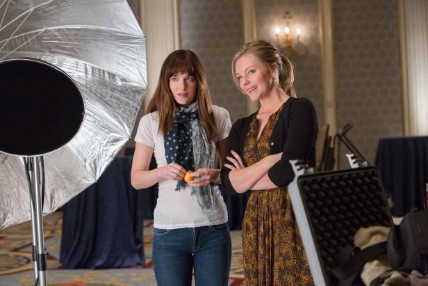 Dakota Johnson und eine weitere Frau stehen in einem Raum mit Fotoausrüstung.
