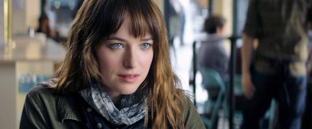 Dakota Johnson trägt einen Schal und eine grüne Jacke.