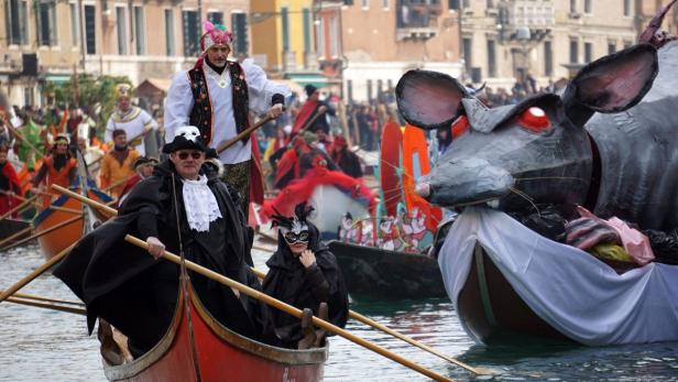 Kostümierte Menschen nehmen an einer Karnevalsparade in Venedig teil.
