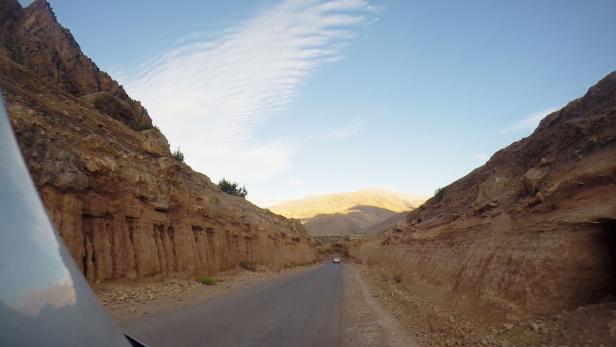 Eine Straße führt durch eine felsige Berglandschaft.