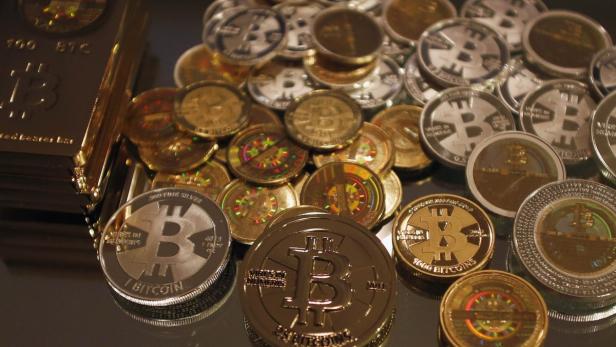 Some of Bitcoin enthusiast Mike Caldwell's coins a Eine Nahaufnahme von Bitcoin-Münzen und Barren in Gold und Silber.