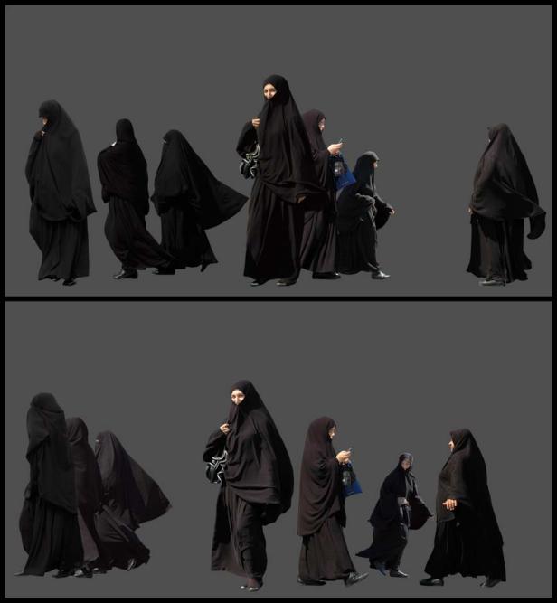 Mehrere Frauen in schwarzen Tschadors gehen auf der Straße.