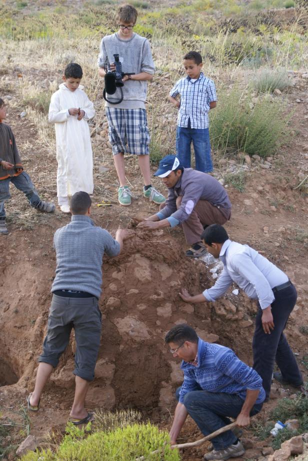 Eine Gruppe von Menschen arbeitet an einem Bauprojekt mit Erde und Lehm.