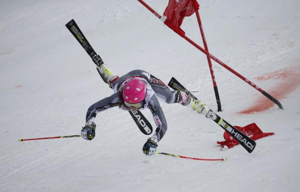 Eine Skirennläuferin stürzt während eines Rennens auf der schneebedeckten Piste.