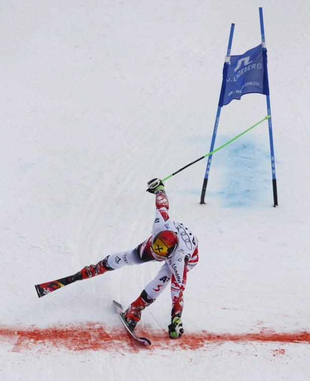 Ein Skirennläufer stürzt während eines Rennens auf der Skipiste.