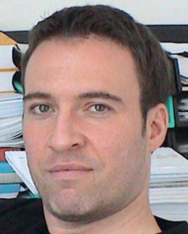 Porträt eines Mannes mit kurzen, dunklen Haaren.