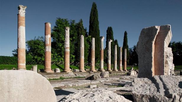 Für Forschung rund um Aquileia sammelt das Österreichische Archäologische Institut Die Ruinen einer antiken Tempelanlage mit Säulen und Steinblöcken.