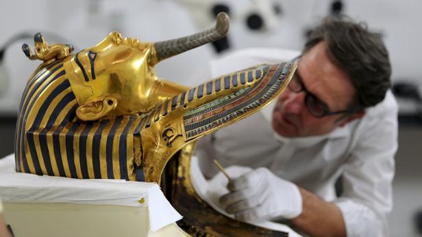 Ein Restaurator arbeitet an der goldenen Totenmaske des Tutanchamun.