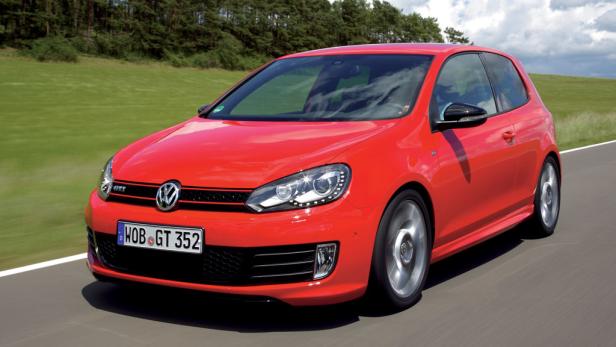 Ein roter VW Golf GTI fährt auf einer asphaltierten Straße.