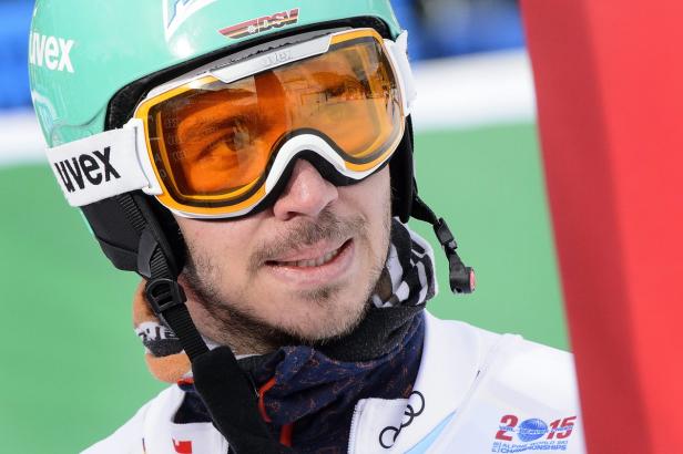 Ein Skifahrer mit Helm und Skibrille blickt in die Ferne.