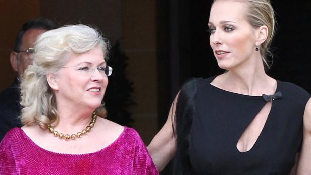 Zwei Frauen, eine in einem pinkfarbenen Kleid und die andere in einem schwarzen Kleid, stehen nebeneinander.