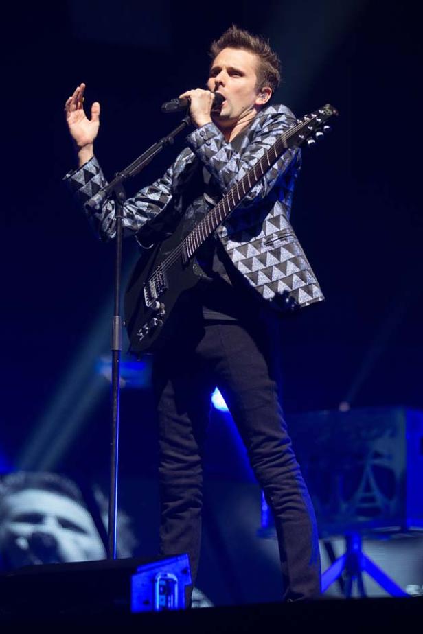 Matt Bellamy von Muse tritt auf der Bühne mit Gitarre und Mikrofon auf.