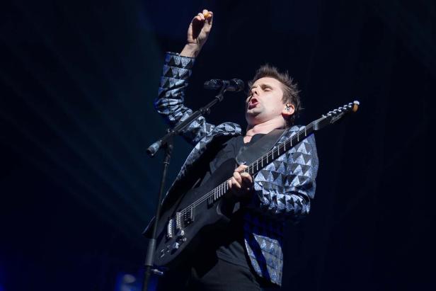 Matt Bellamy von Muse spielt Gitarre auf der Bühne.