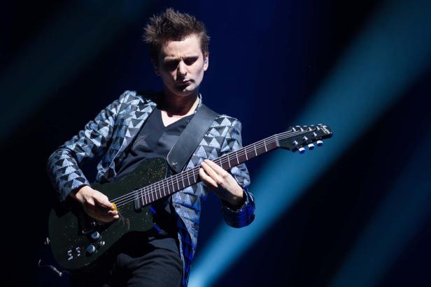 Matt Bellamy von Muse spielt Gitarre auf der Bühne.