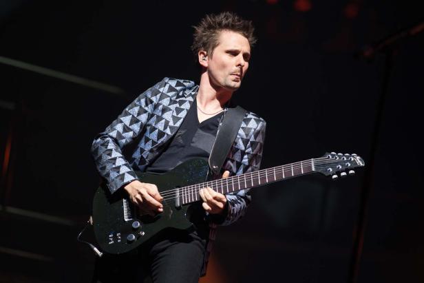 Matthew Bellamy von der Band Muse spielt Gitarre auf der Bühne.