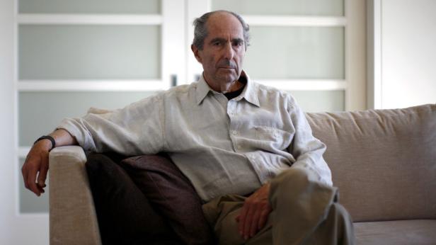 Ein älterer Mann sitzt entspannt auf einem Sofa.