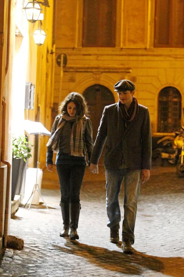 Ein Paar geht händchenhaltend eine beleuchtete Gasse entlang.