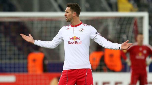 Ein Fußballspieler im Trikot von RB Leipzig gestikuliert auf dem Spielfeld.