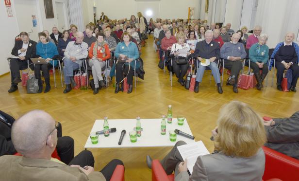 Ein Publikum sitzt bei einer Veranstaltung in einem Raum.