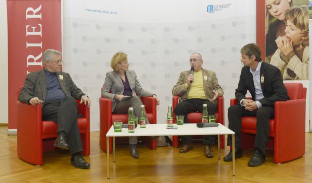 Vier Personen sitzen in roten Sesseln bei einer Pressekonferenz der Medizinischen Universität Wien.