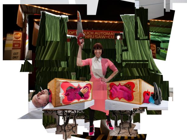 Eine Frau mit Säge posiert neben zwei Kisten, aus denen ein Kopf und Füße ragen.