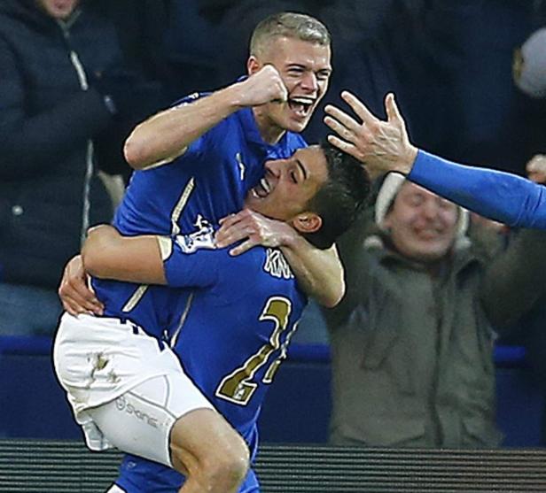 Zwei Fußballspieler in blauen Trikots umarmen sich jubelnd.