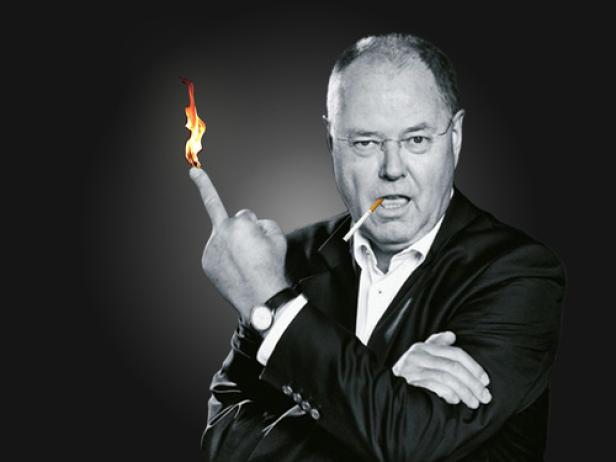 Ein Mann mit Zigarette im Mund lässt eine Flamme auf seinem Finger brennen.