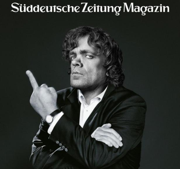 Schwarzweiß-Porträt von Peter Dinklage, der den Mittelfinger zeigt.