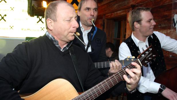 Eine Musikgruppe spielt mit Gitarren und Mundstücken in einem Raum.