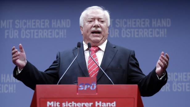 Ein Mann mit Schnurrbart hält eine Rede auf einer SPÖ-Veranstaltung.