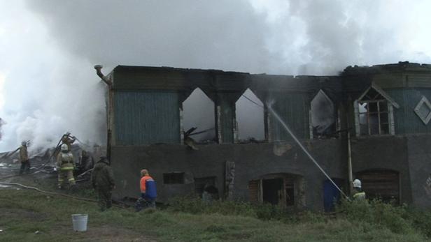 Feuerwehrleute löschen ein brennendes Gebäude.
