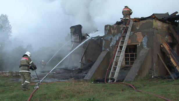 Feuerwehrleute löschen ein brennendes Gebäude.