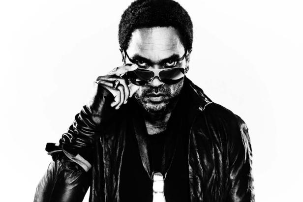 Ein Mann mit Afro-Frisur und Sonnenbrille blickt ernst in die Kamera.