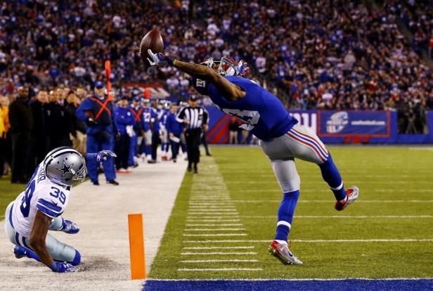 Ein Footballspieler der New York Giants fängt einen Pass vor einem Gegenspieler der Dallas Cowboys.