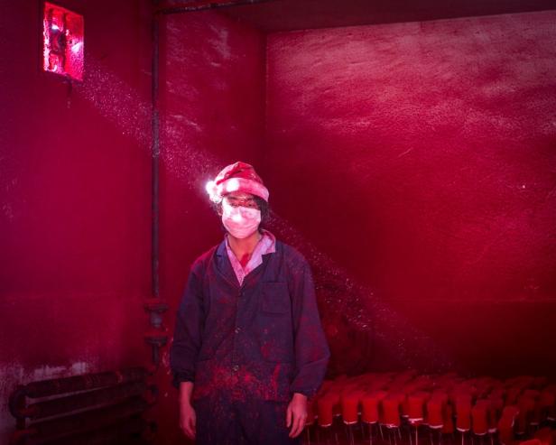 Eine Person mit Santa-Mütze und Maske steht in einem rot bespritzten Raum.