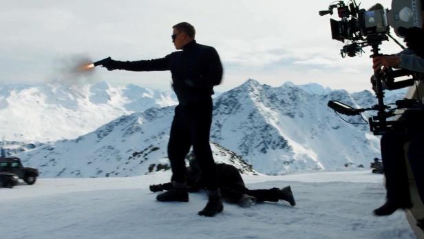 Daniel Craig als James Bond während einer Schießszene in den Bergen.