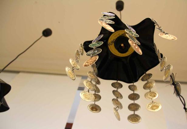 Ein Mobile aus einer Schallplatte und Kaffeekapseln hängt von der Decke.