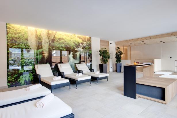 Ein Ruheraum mit Liegen und einem Wandbild eines Wasserfalls.